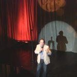 American comedian Shaun Eli spot-lit on stage at Cape Town Comedy Club in South Africa