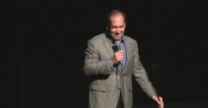 Comedian Shaun Eli on stage at a New York theatre