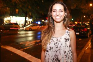 Liz Miele standing on a street corner at night with taxis in the background