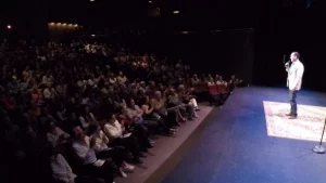 Stand-up comedian Shaun Eli on stage in front of an applauding audience