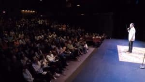 Shaun Eli on stage at the Emelin Theatre in New York, in front of an applauding audience.